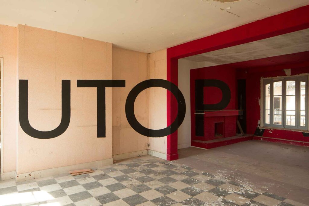 Word "Utopia" in large stick letters on the walls of an empty flat, Exhibition by Georges Rousse, Familistère